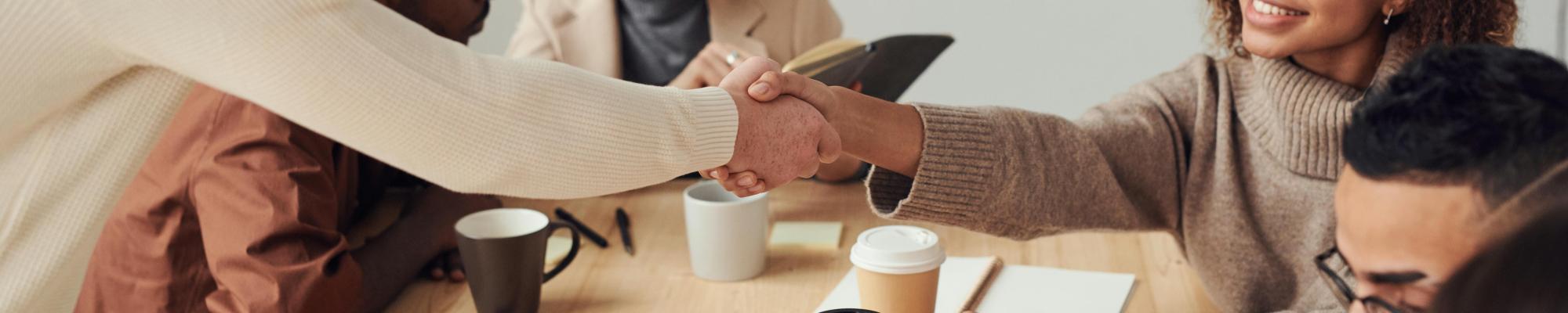 A group of people working together and shaking hands.